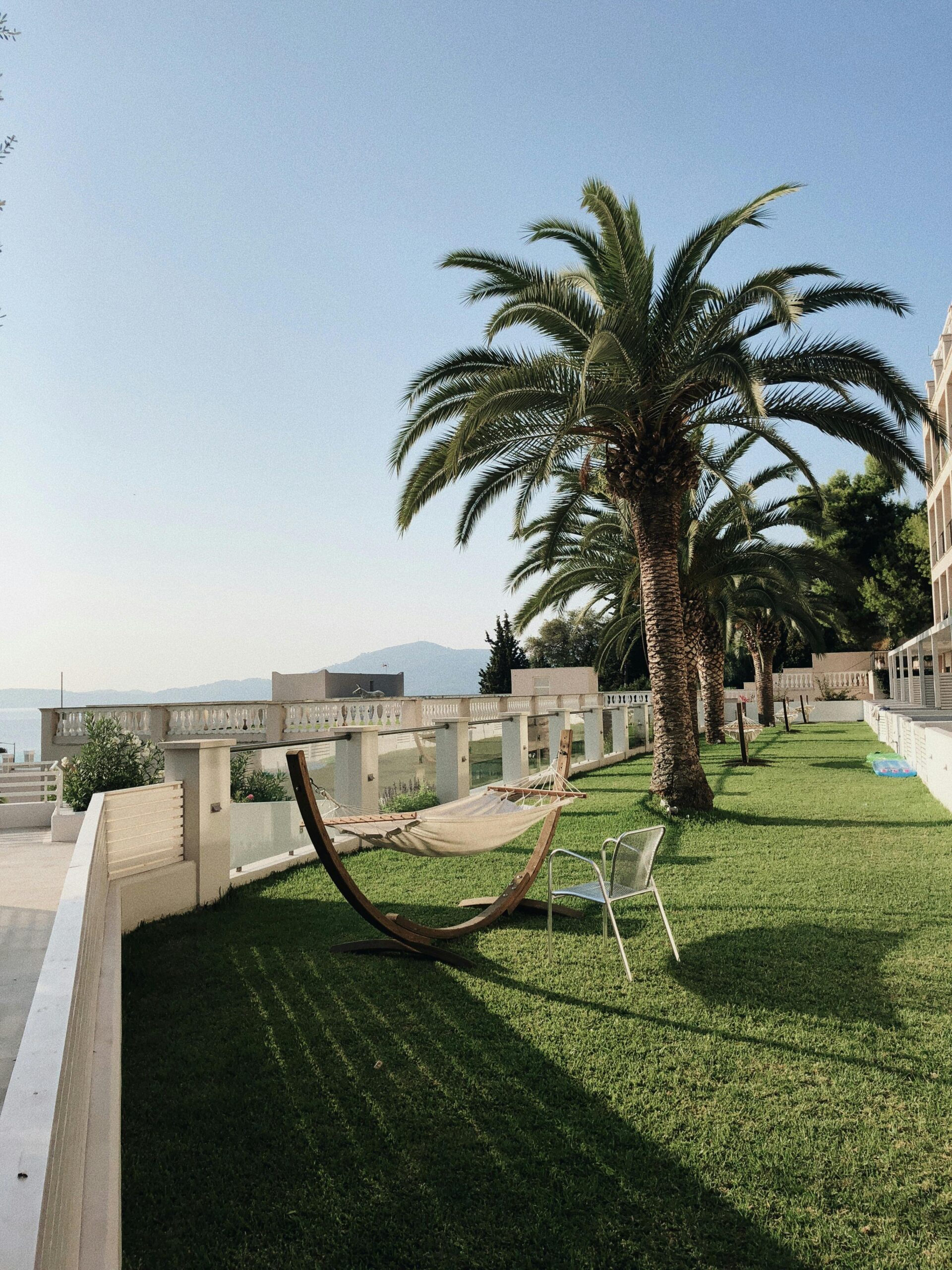 Relax by the ocean with a hammock and palm trees at a serene resort.