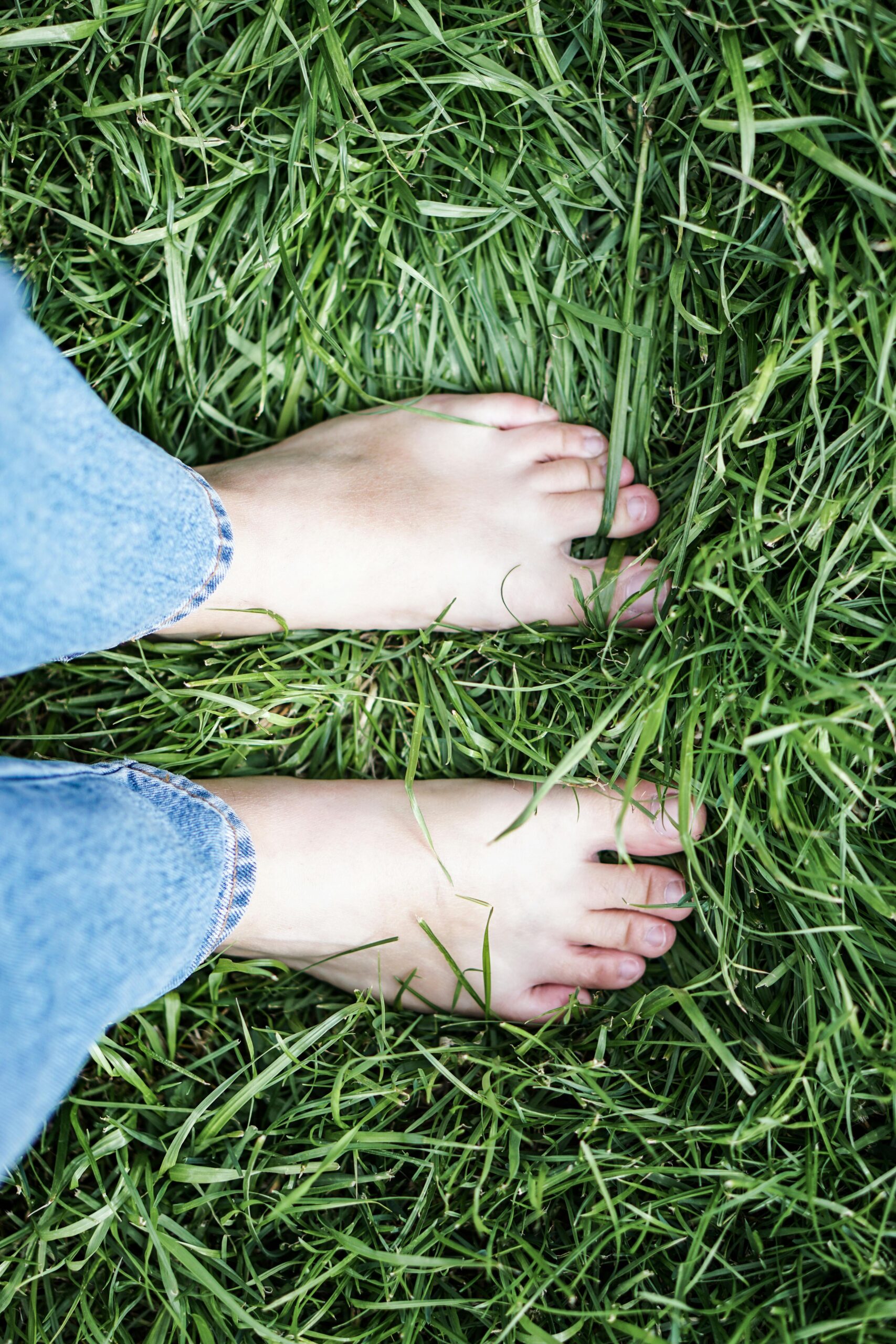 Peaceful moment of bare feet on lush grass, symbolizing relaxation and connection with nature.